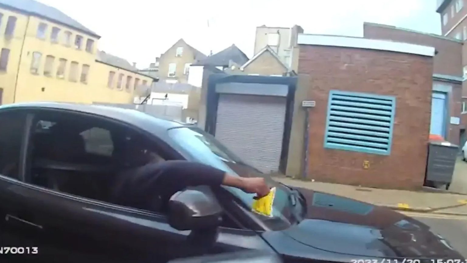 Terrifying moment parking warden shoved to the floor & repeatedly punched after slapping ticket on driver’s windscreen