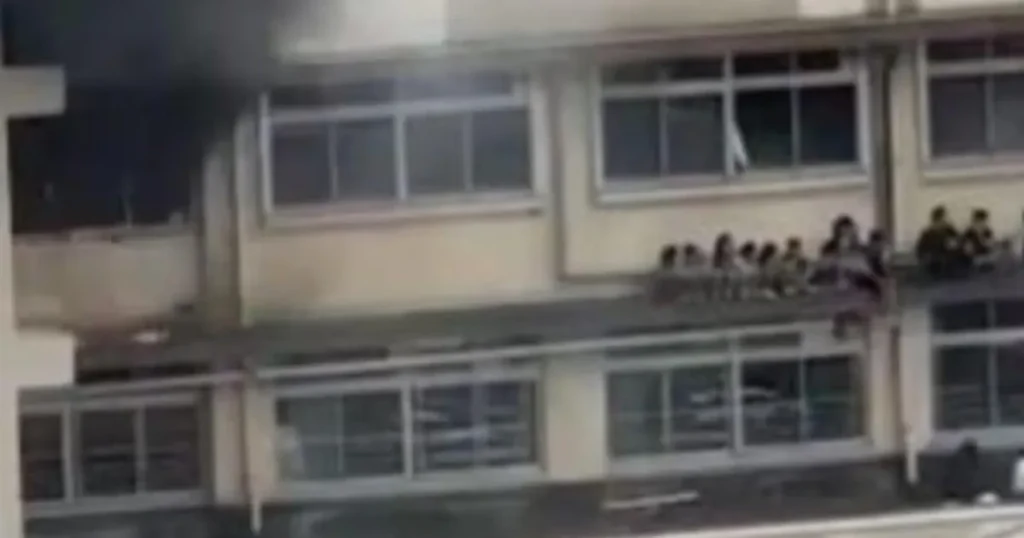 Children cower on a ledge while fleeing fire that engulfed their school