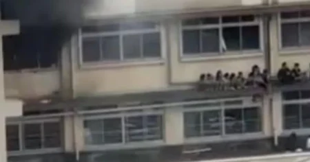 Children cower on a ledge while fleeing fire that engulfed their school