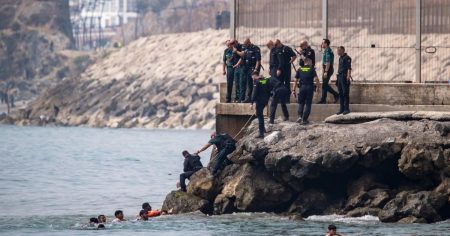 Thousands of migrants storm onto Spanish beach after overwhelming police