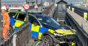 Police car dangling precariously off seaside pier in crash trapping two officers